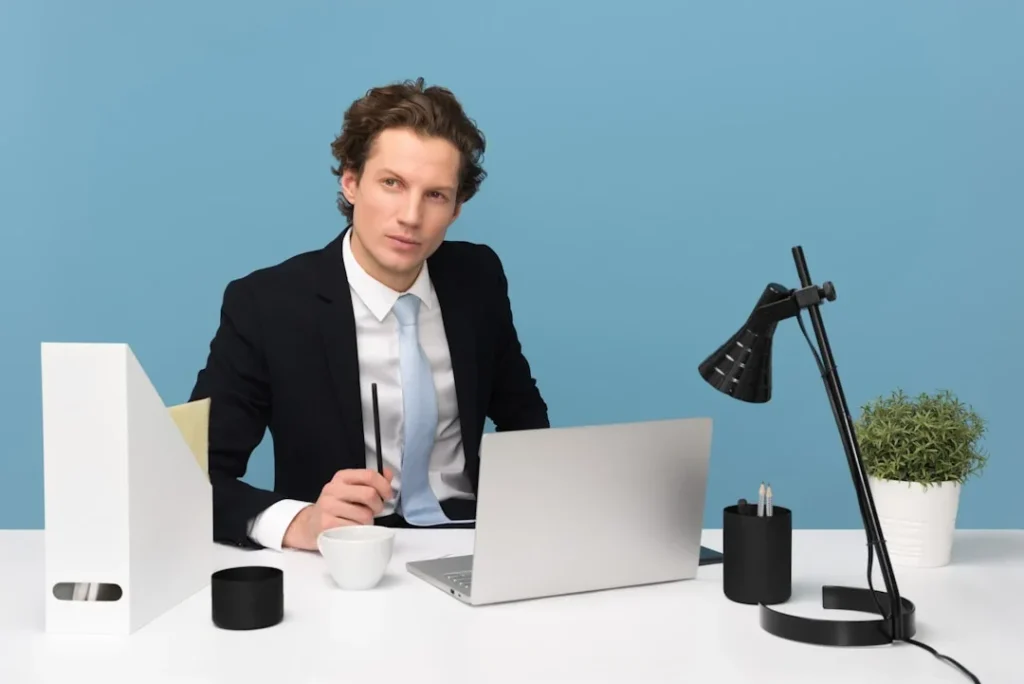 What Is Proposal Automation? A man in a suit sits at a desk with a laptop