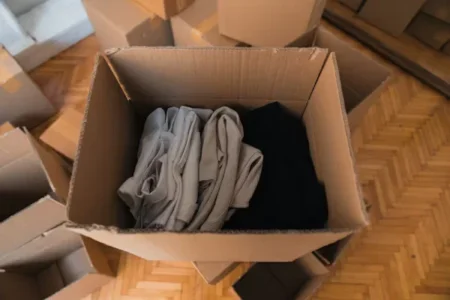 a cardboard box filles with colorful clothes
