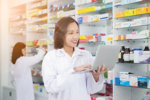 female pharmacist holding laptop in her hands