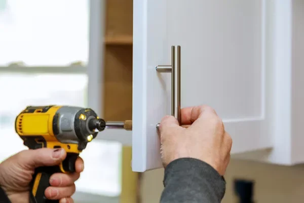 Why Custom Cabinet Hinges Are a Game Changer for Unique Furniture Designs person installing cabinet handle