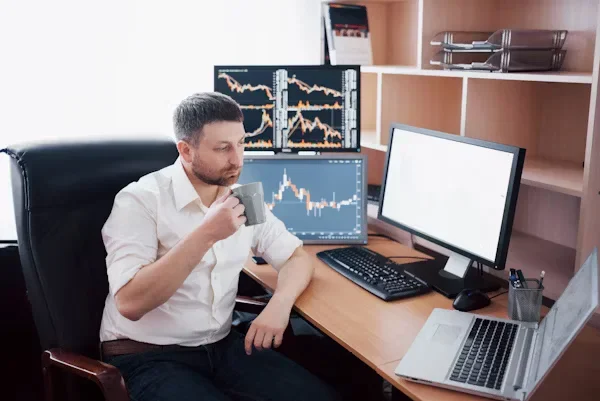Index Funds vs. ETFs vs. Individual Stocks: Pros and Cons a man sitting in front of table drinking coofee