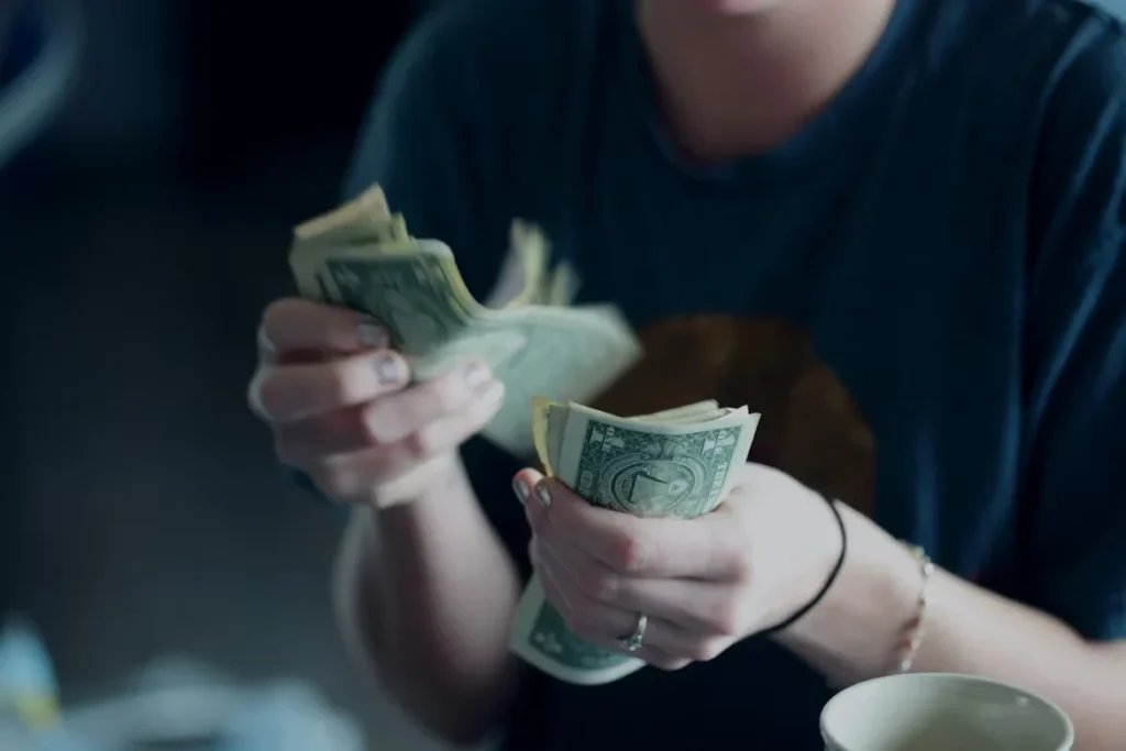 How to Purchase Vintage Clothing in Mystery Boxes with Luck a person counting dollars