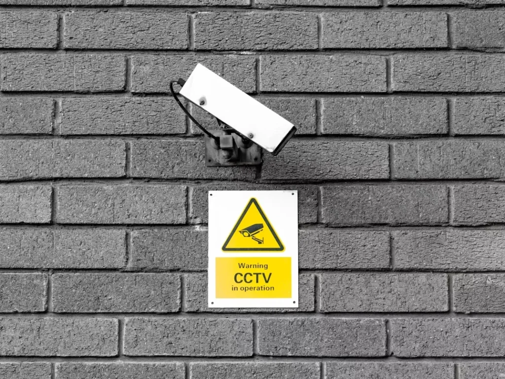 Why Las Vegas Businesses Choose Professional Camera Installation a white CCTV camera on grey brick wall