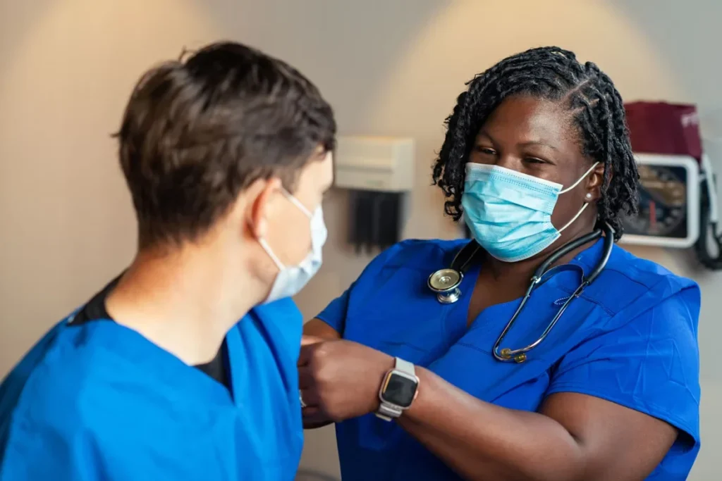 The Role of Nurse Practitioners: Raising the Standard of Patient Care Facility-Wide a woman in blue scrub and a man in blue scrub