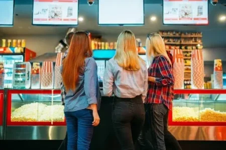 girl standing in front of pop corn station