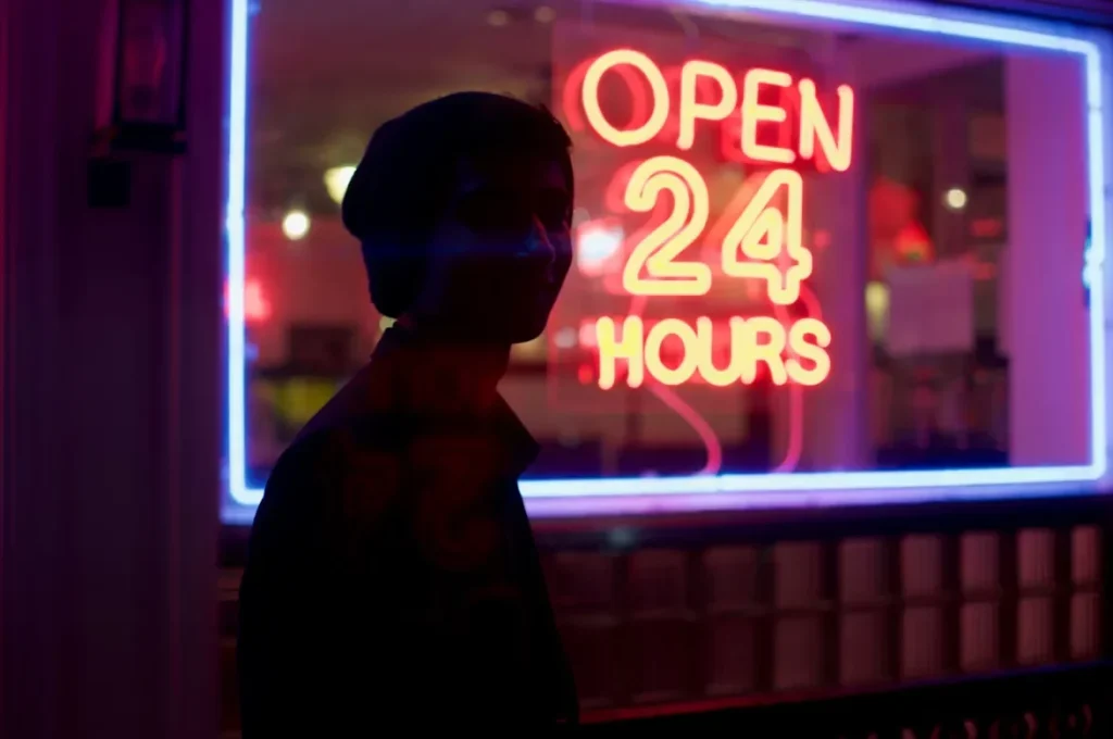 Movie Night Made Easy: Autonomous Checkout for Theater Concessions man standing besides 24 hours signage during nighttime