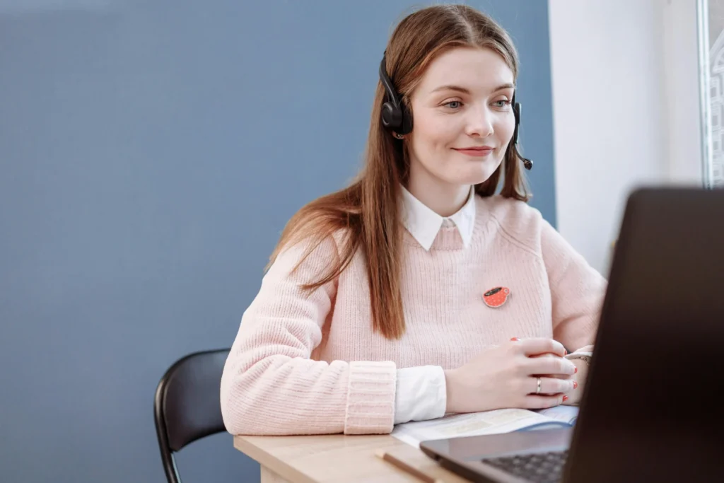 How Can a Virtual Assistant Simplify Local News Marketing? woman in pink sweater wearing headset