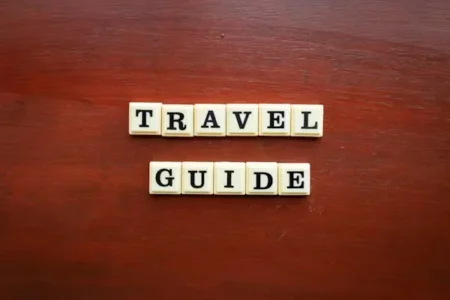 Word TRAVEL GUIDE written with scrabbles