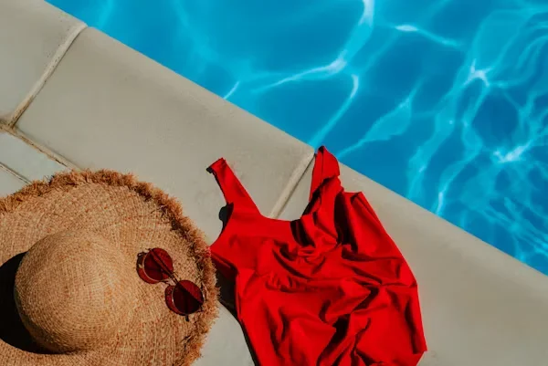 Gift Ideas for Travelers This Summer: 10 Gifts They'll Use a hat and red shirt near swimming pool
