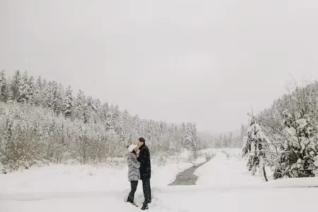 a man and woman standing in snow