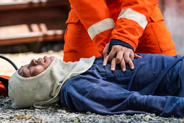 Why Truck Accident Cases Are Often More Complicated Than Car Accidents a man giving CPR to a man laying on road