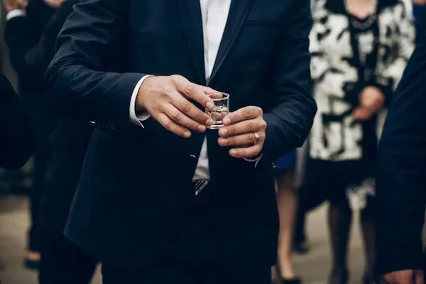 What to Wear to Networking Events Without Looking Overdressed or Underwhelming a man holding glass in his hand