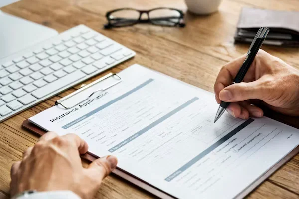 Why Truck Accident Cases Are Often More Complicated Than Car Accidents a person filling insurance form