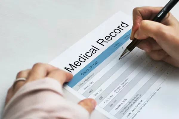 The Emotional Losses You Can Recover Through a Car Accident Claim a person filling medical record form.
