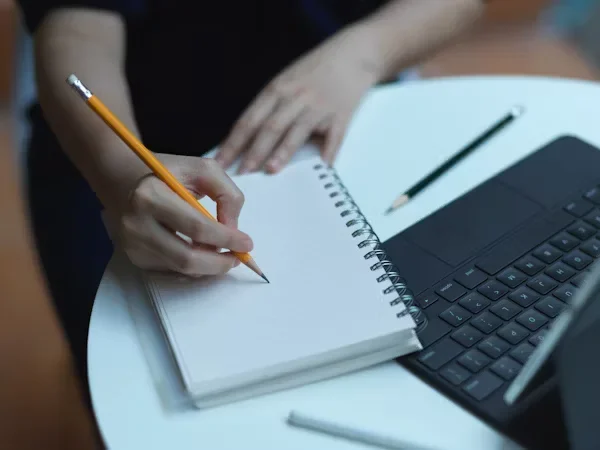 a person writing on a note book