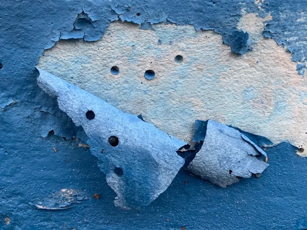 a piece of blue paint with holes in it