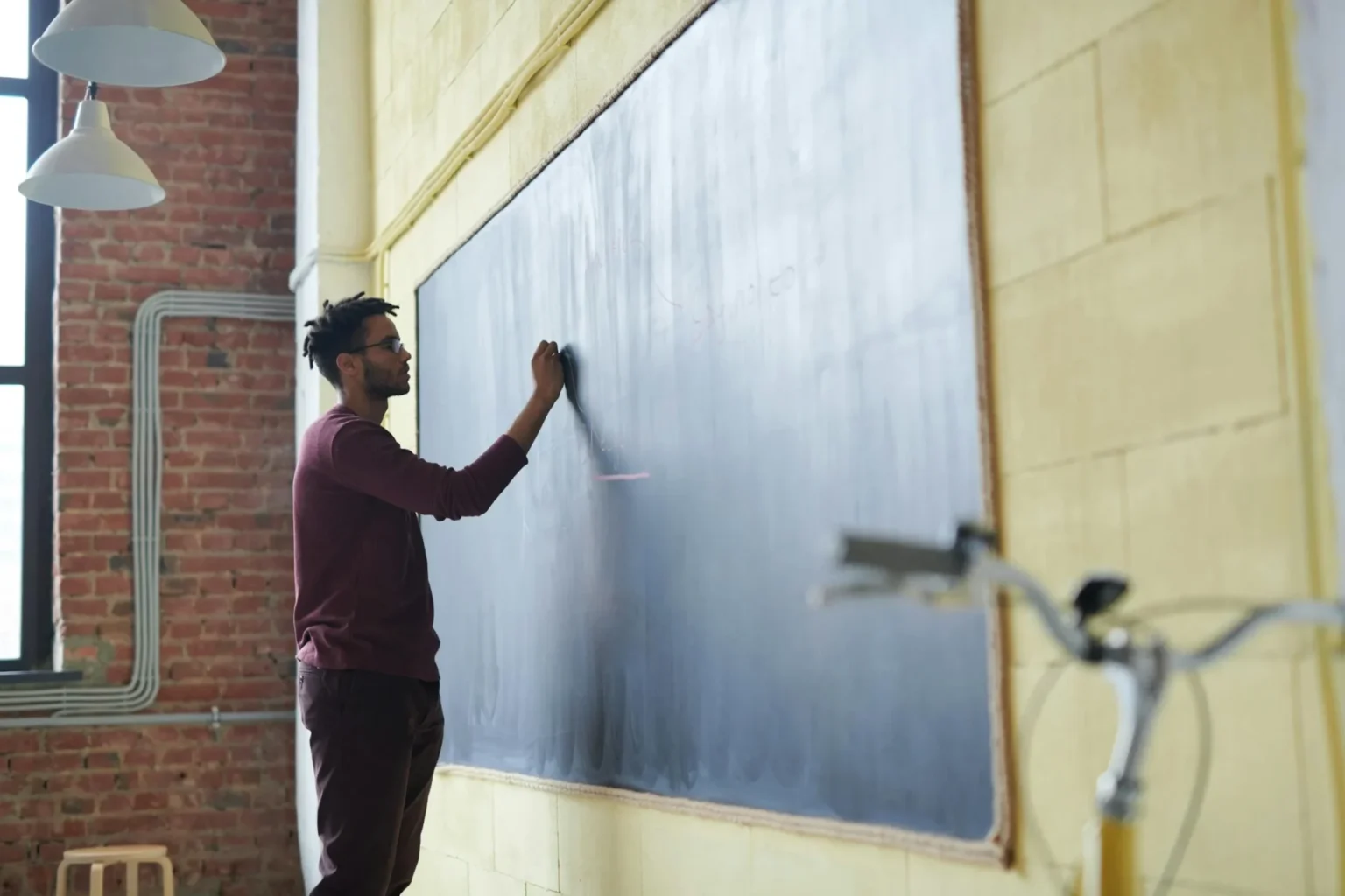 man writing on black board