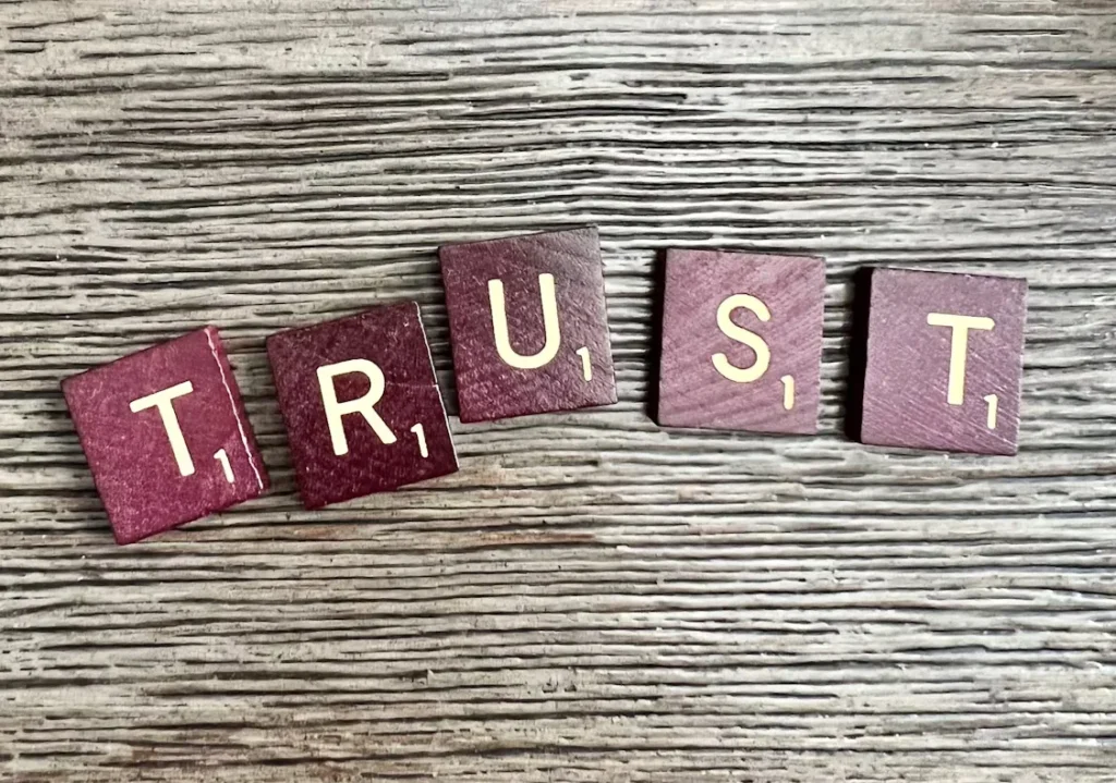 trust spelled with wooden letter blocks on table