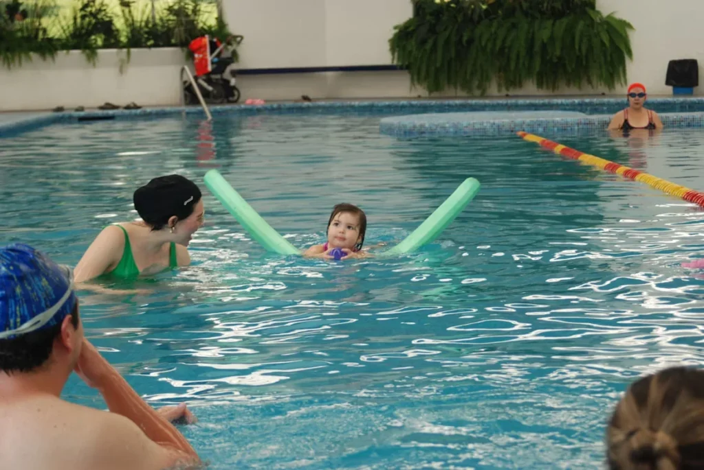How Early Swim Lessons Build Lifelong Skills A group of people in a swimming pool