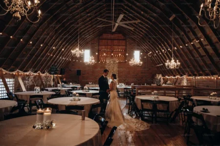 a bride and groom standing in the barn