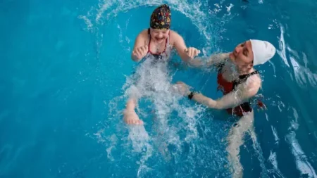 a child and woman in water swimming