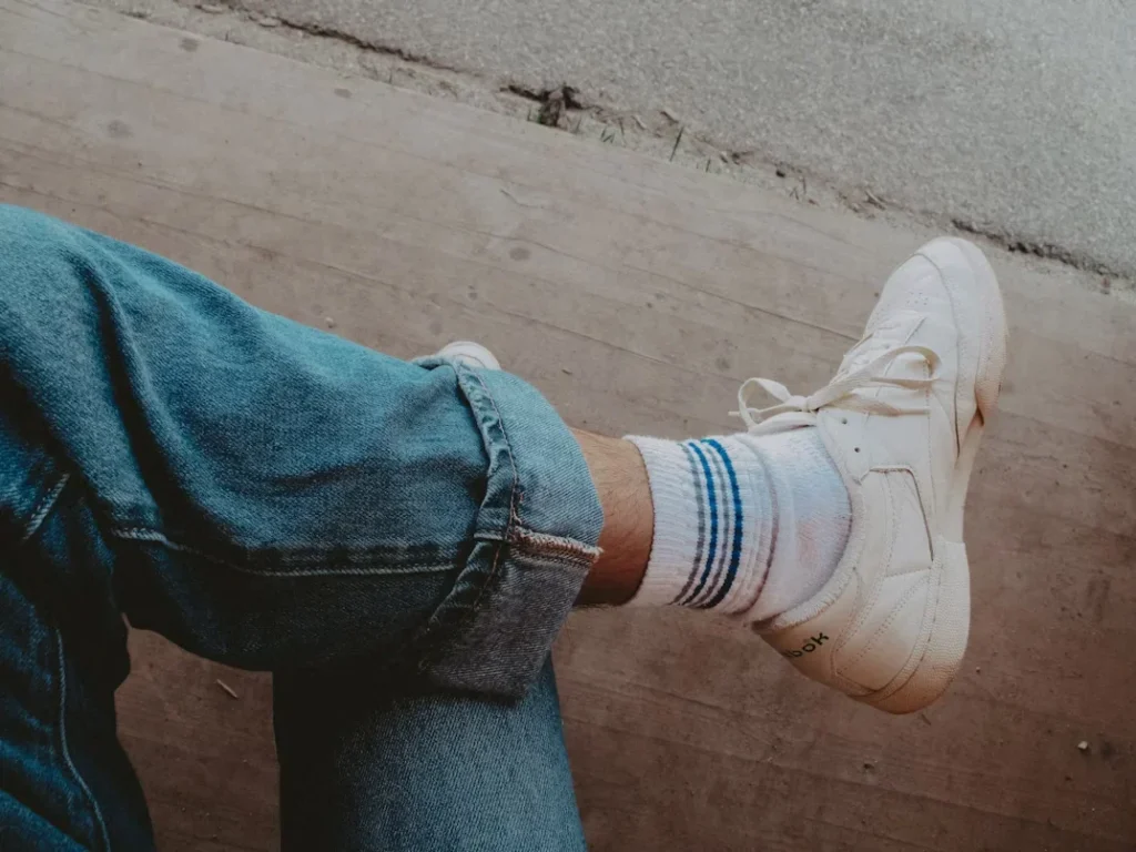 Why Crew Socks Are a Wardrobe Essential for All a person with their feet up wearing white jogger