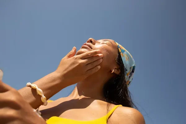 a woman applying sunscreen on her face