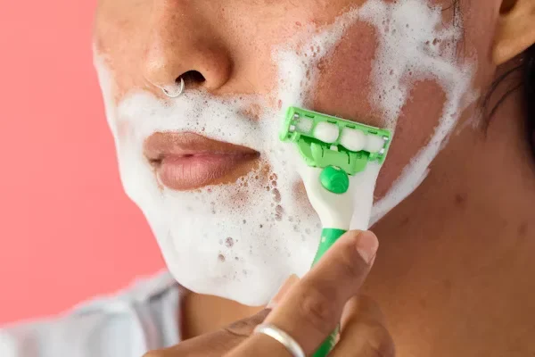 7 Real-World Tips for Surviving Your First Laser Hair Removal (Without Freaking Out) a woman shaving her face