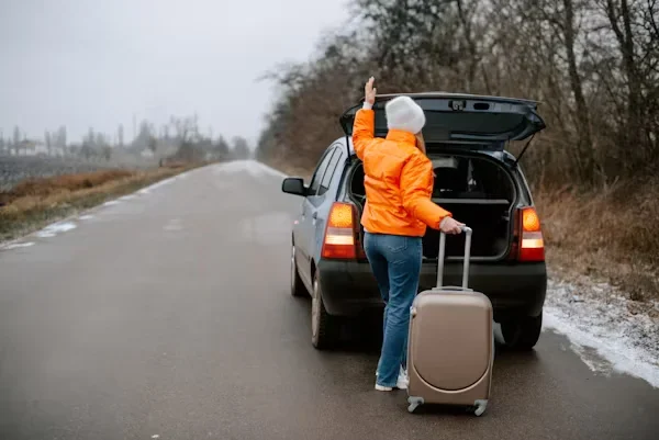 How to Start Fresh in a New City a woman wearing in orange jacket holding suitcase