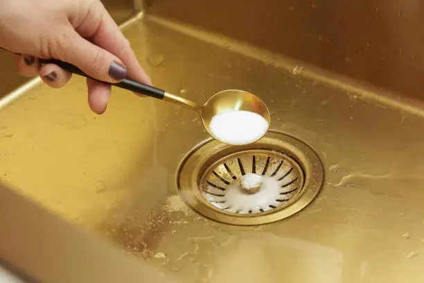 woman adding baking soda in the sink