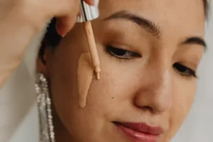 A woman applying foundation on her face