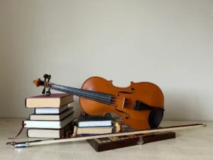 a violin sitting on a top of pile of books