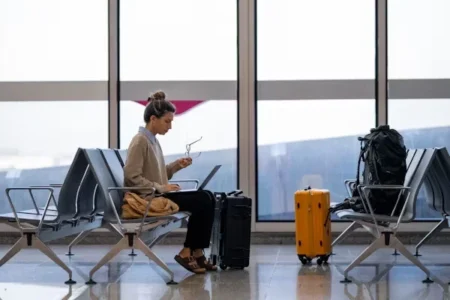 a woman using laptop while sitting at airport