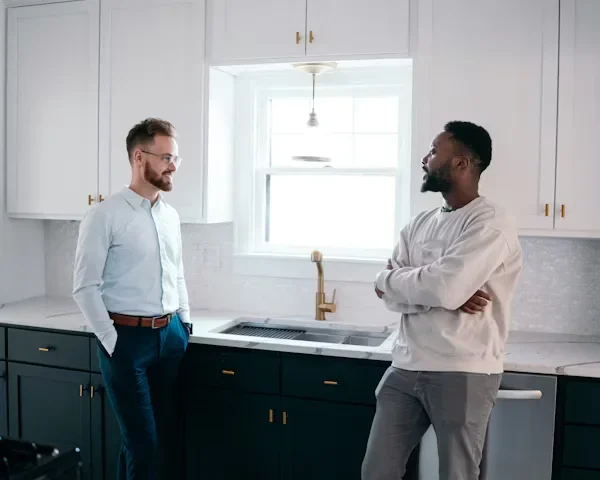 two men standing in kitchen