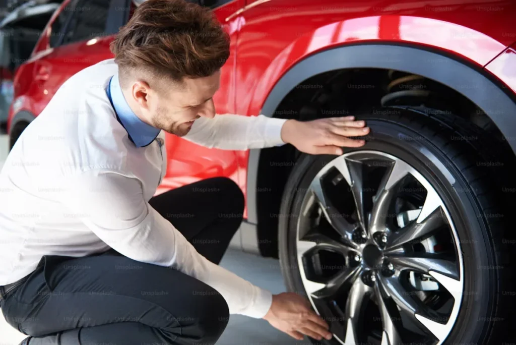 a man checking tyres of a car
