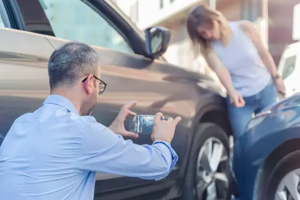 a man taking picture of a car
