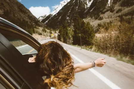 woman putting her head out of car windoe