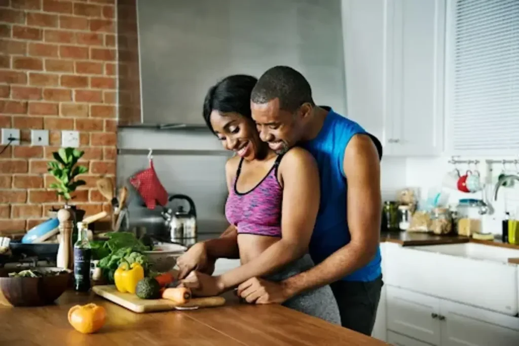 Nutrition, Activity & Culture: Modern Wellness in Traditional Places a man and woman standing in kitchen