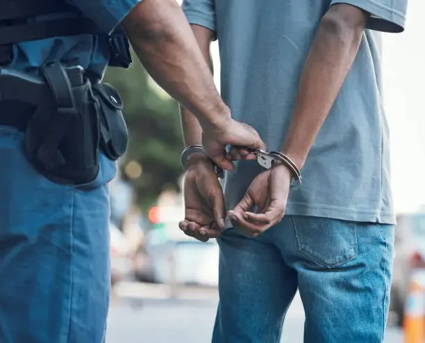 What to Expect When Facing the Criminal Justice System a man standing in handcuffs