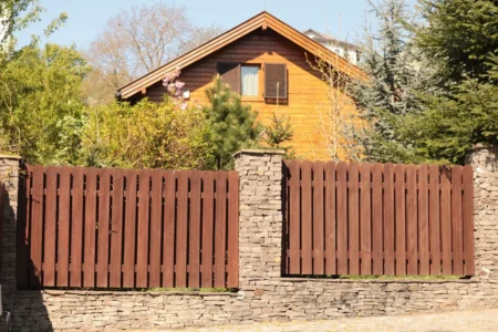 a wooden house behind wooden frnce