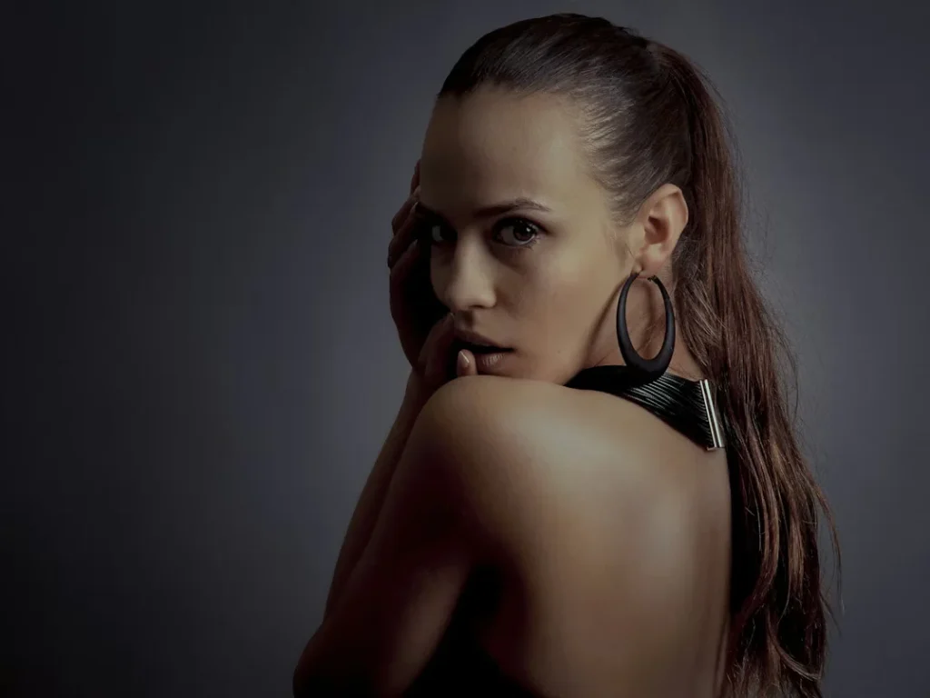 a girl posing wearing black hoops.