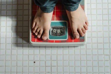 Balancing Weight-Loss Goals with Side Effect Management a person standing on weighing machine